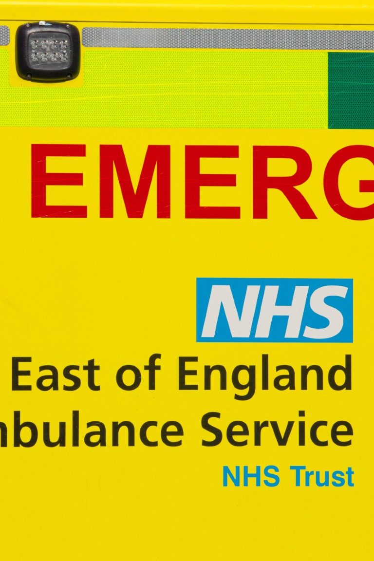 A close up image of a bright yellow ambulance with NHS in large letters A close up image of a bright yellow ambulance with NHS in large letters